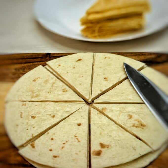 sliced tortilla on top of of a chopping board with knife