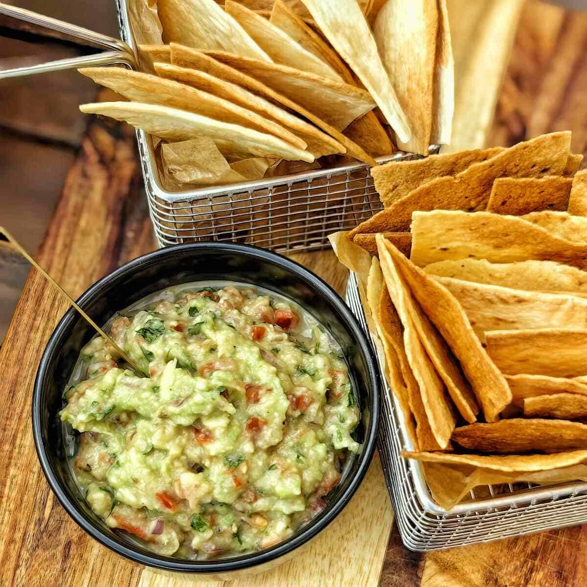 air fryer tortilla chips with guacamole on a bowl