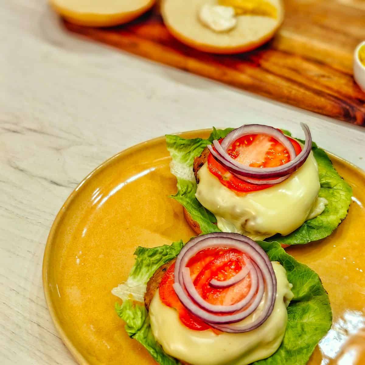 air fryer turkey burgers with cheese on top of lettuce, onions and tomatoes