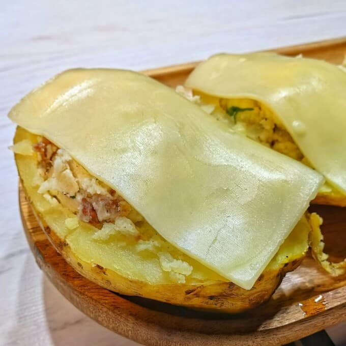 potato halves with filling mixture and cheese on top
