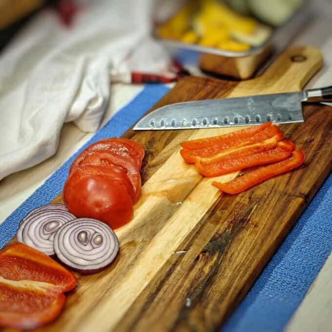 sliced eggplant, onion, and tomato on a cutting board