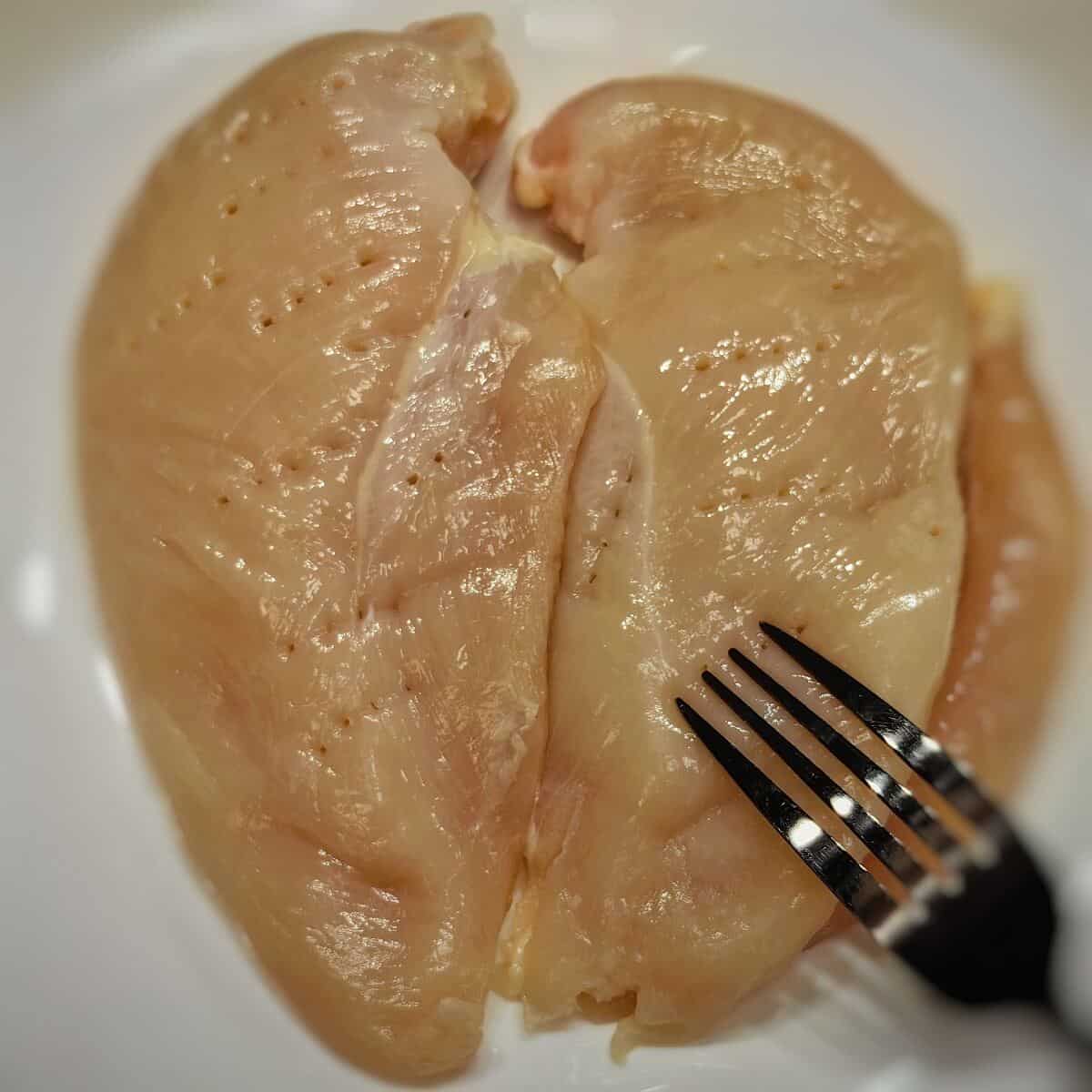 fork poking chicken breast