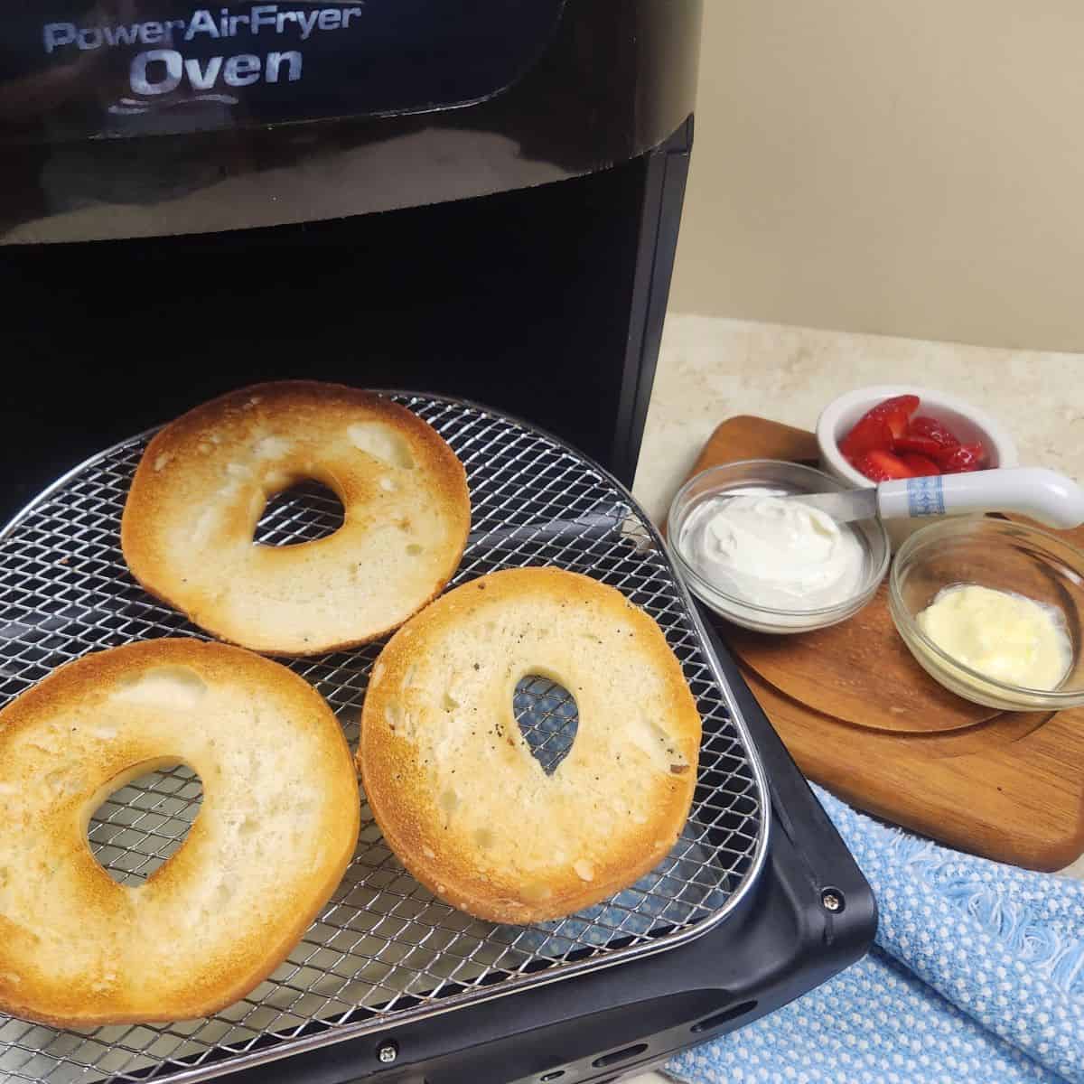 toasted bagels using air fryer beside different spreads