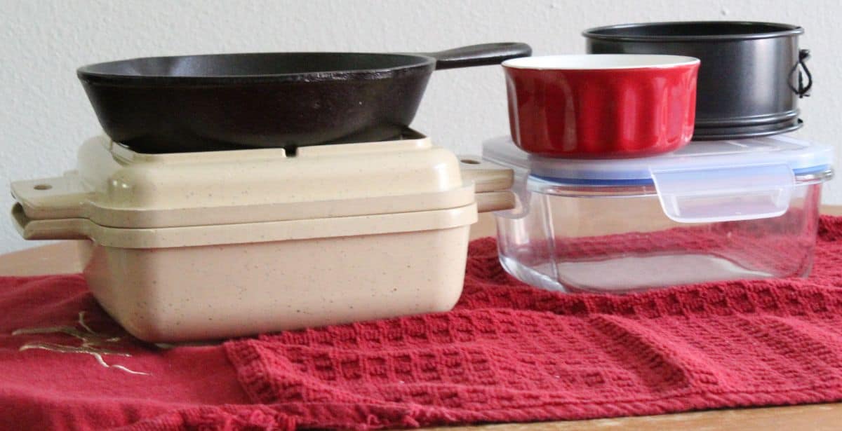 casserole dishes and cast iron pan on top of kitchen towel