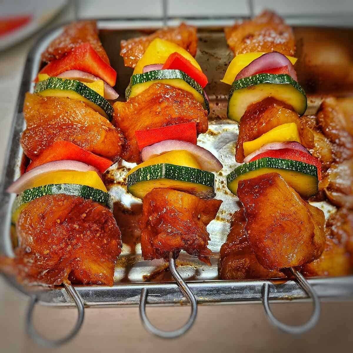raw chicken kabobs in metal container