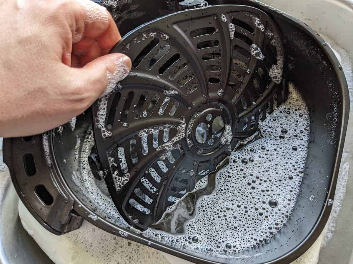 cleaning metal plate and air fryer basket with soapy water