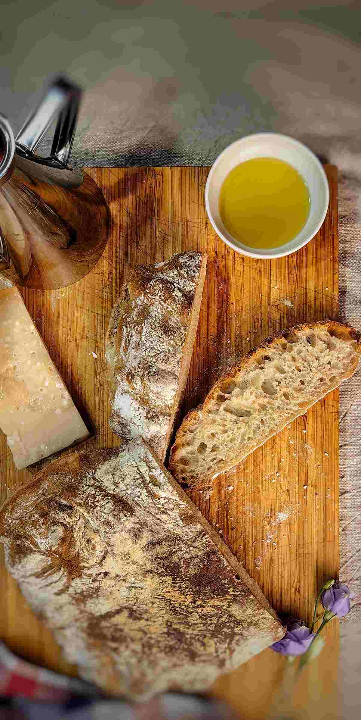 sliced ciabatta bread with olive oil and cheese on chopping board