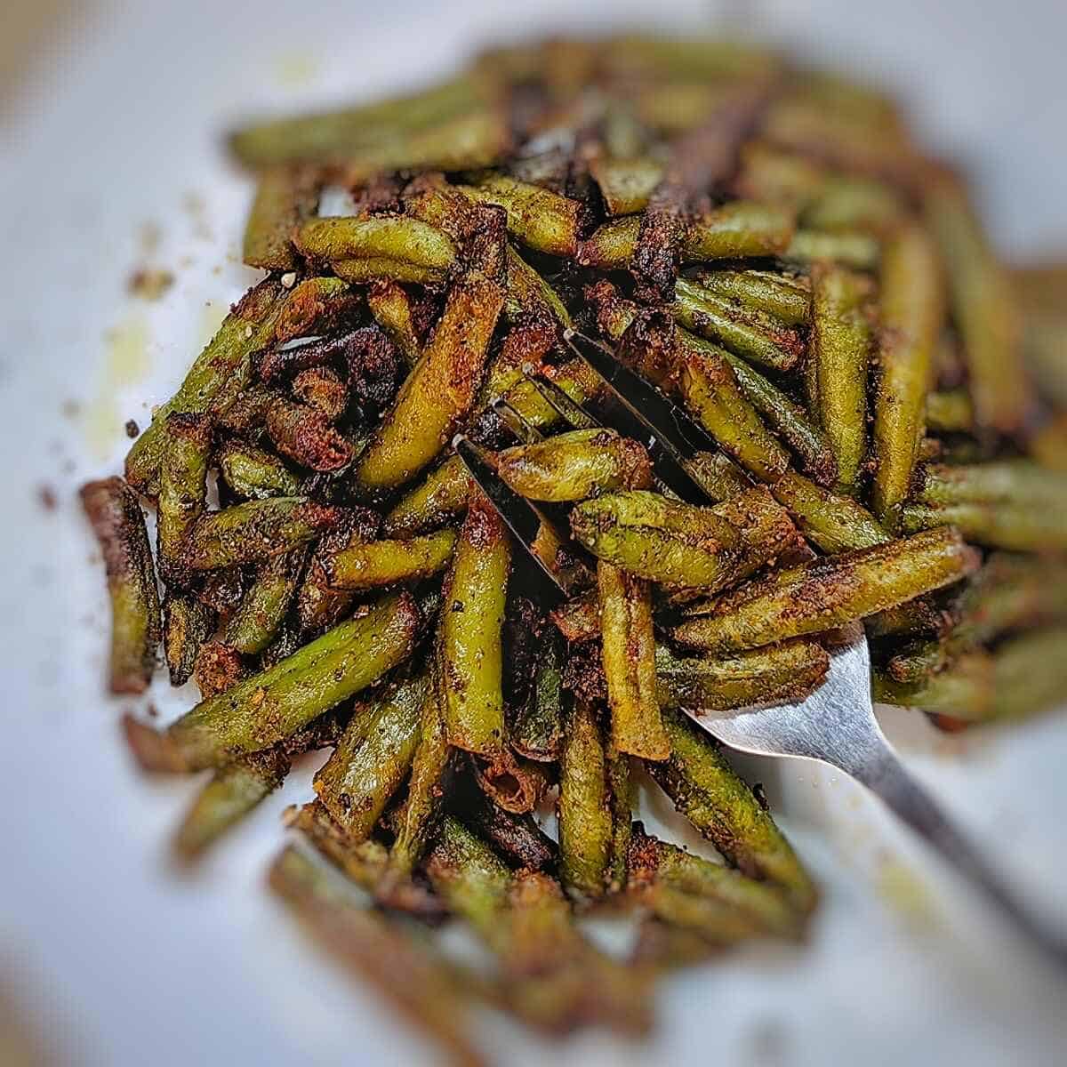air fryer frozen green beans on a serving plate with fork