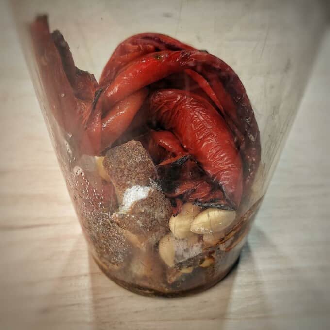 peeled roasted peppers and ingredients inside blender cup