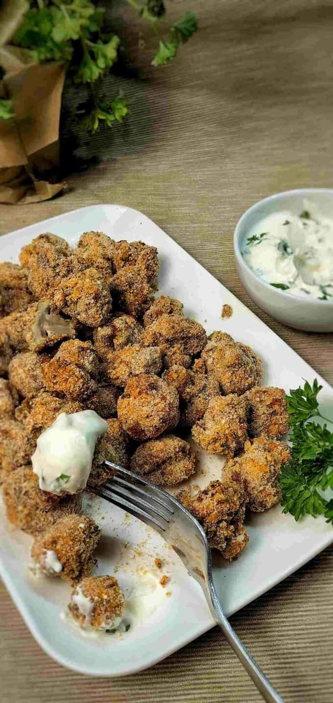 air fryer fried mushrooms with white sauce and garnish