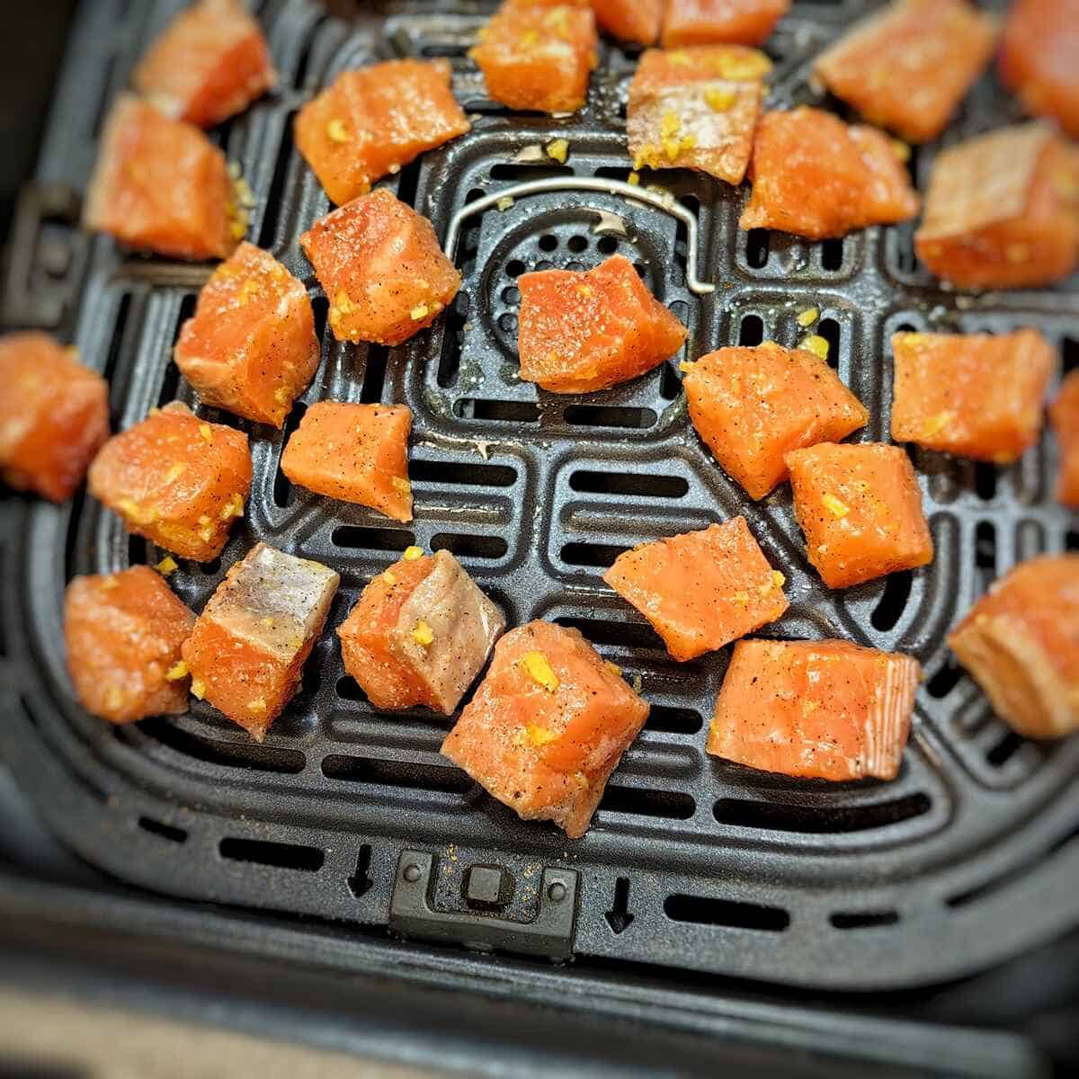 marinated salmon slices inside air fryer basket