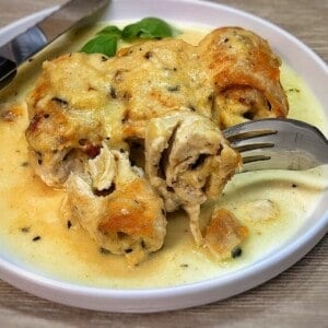 air fryer stuffed chicken breast roll-ups on a serving plate with knife and fork