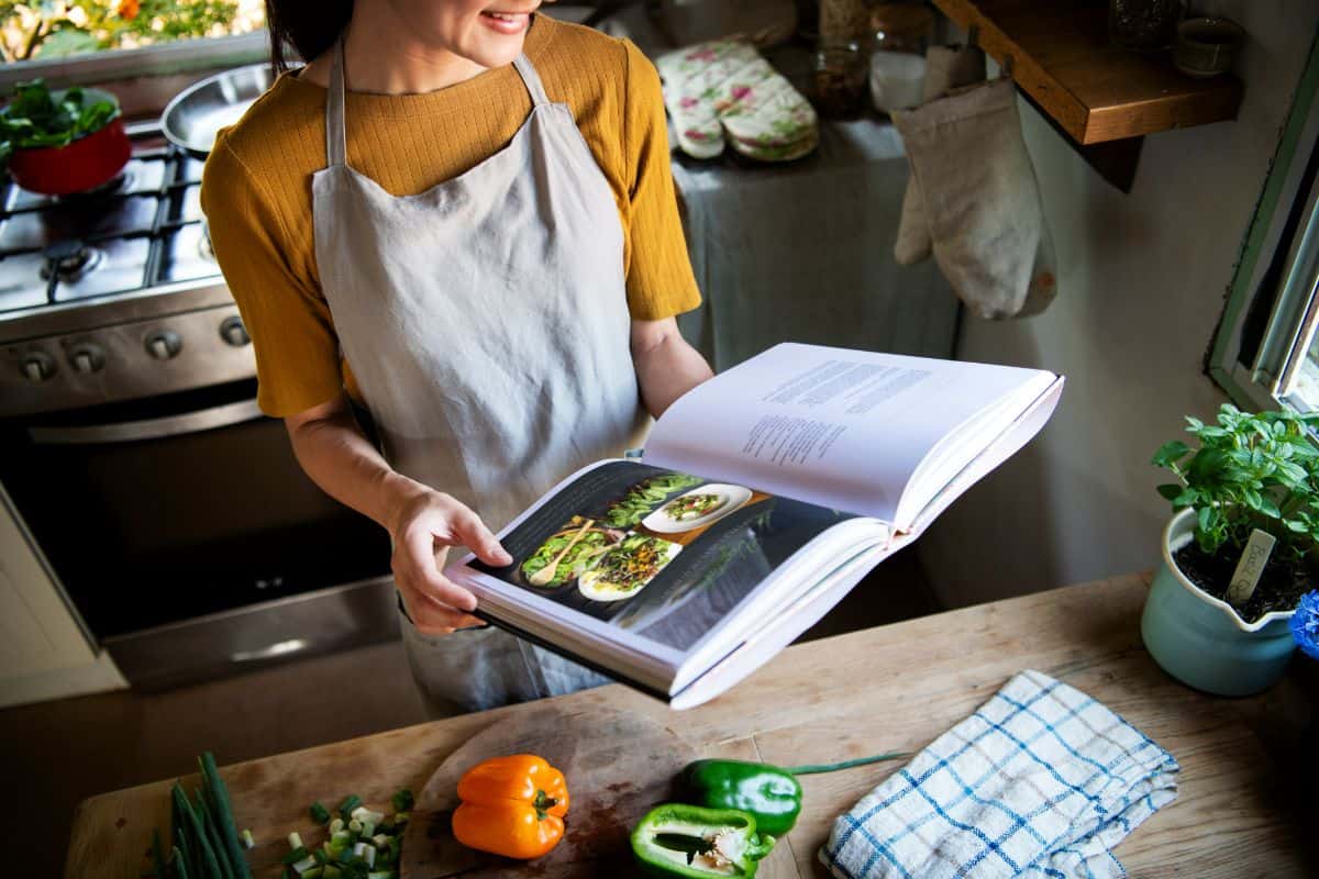 woman holding a cookbook in the kitchen