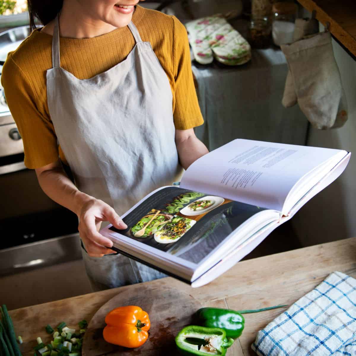 woman holding a cookbook in the kitchen