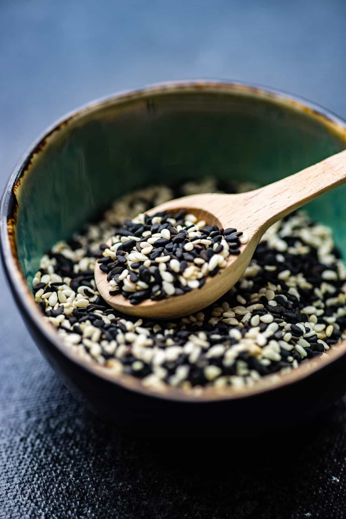 organic sesame seeds in a bowl on concrete background