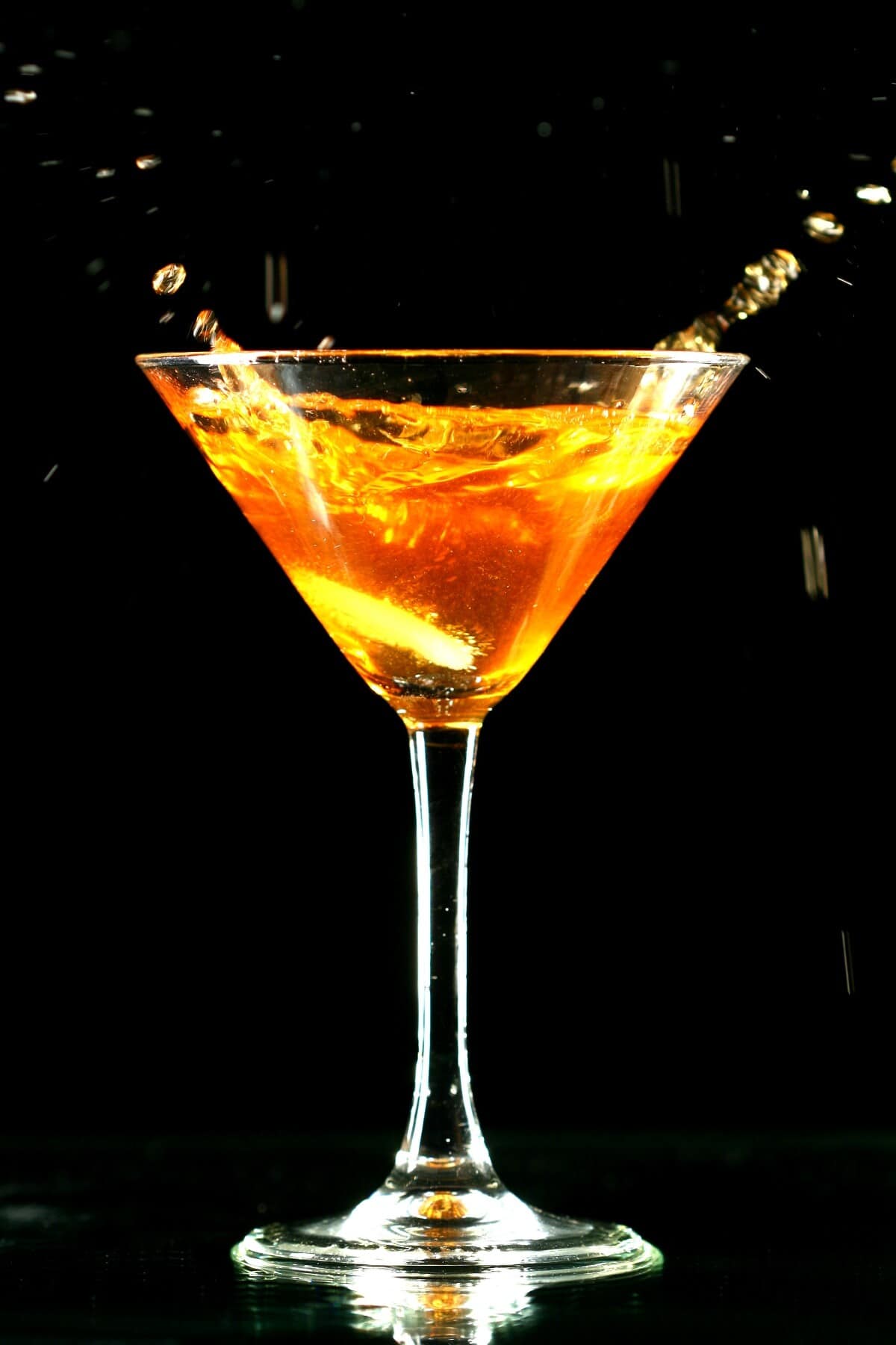 alcohol coctail in martini glass on black background