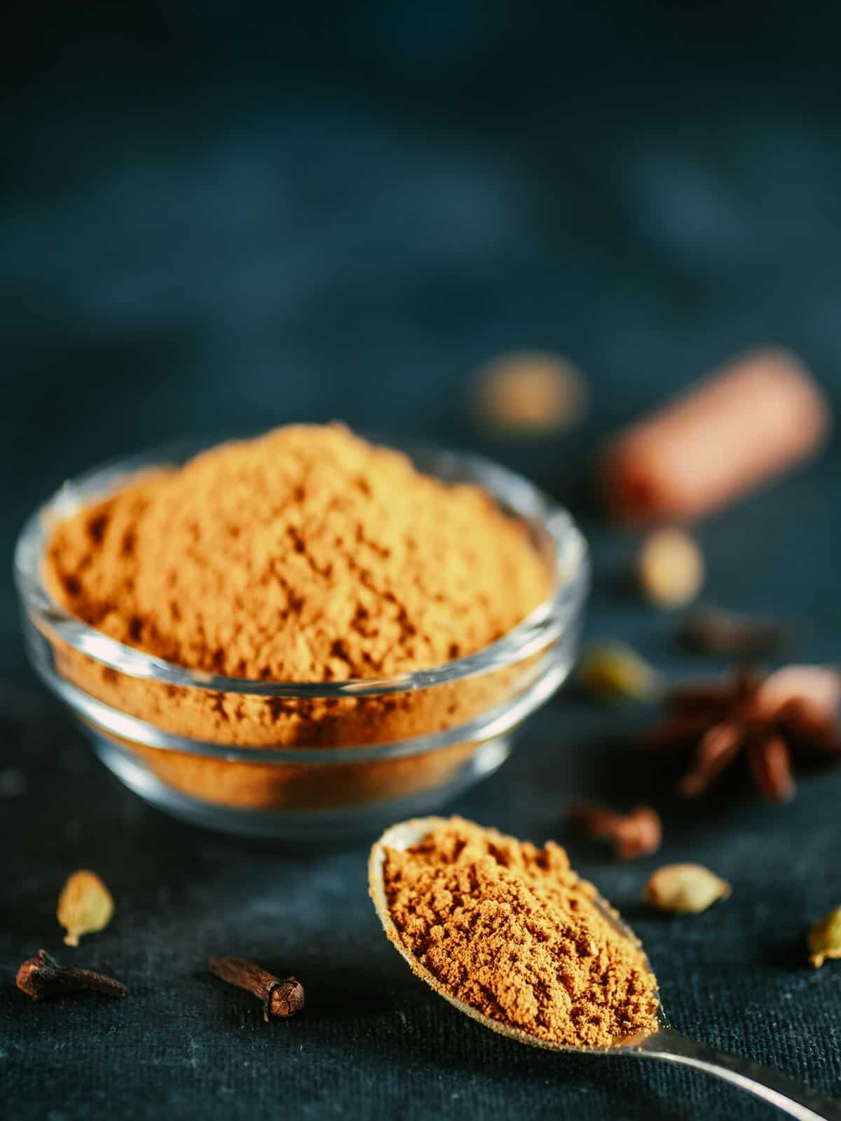 masala powder in spoon and glass jar