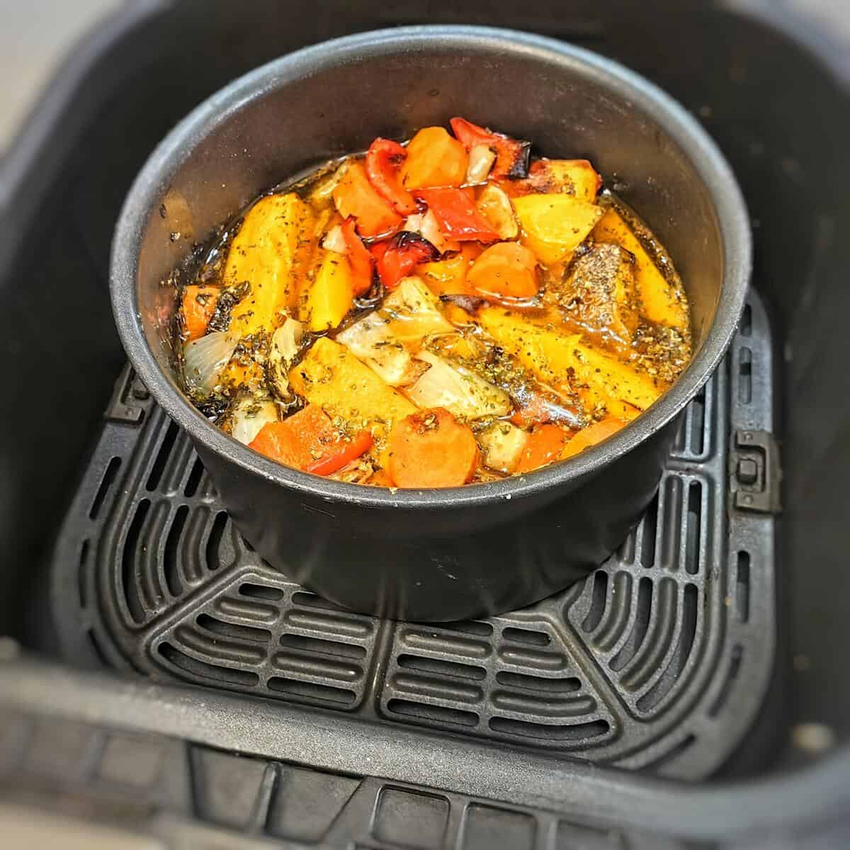 oven safe pot with roasted vegetables inside air fryer basket