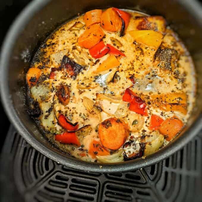 roasted vegetables with broth and cream in a pot inside air fryer basket