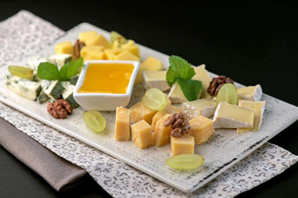 cheese plate with honey, grapes and nuts