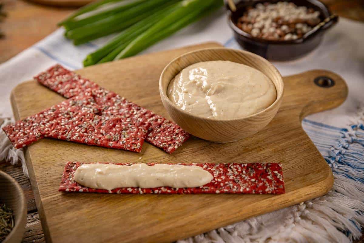 tahini in bowl and red beetroot crackers