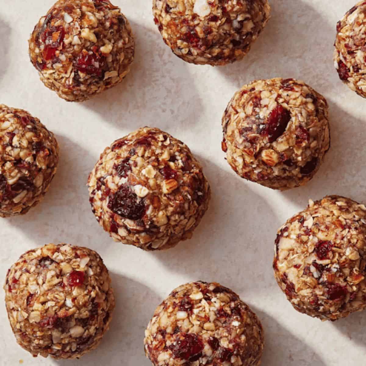 A close-up of cranberry-almond energy balls, featuring a mix of dried cranberries and chopped almonds, rolled into bite-sized spheres.