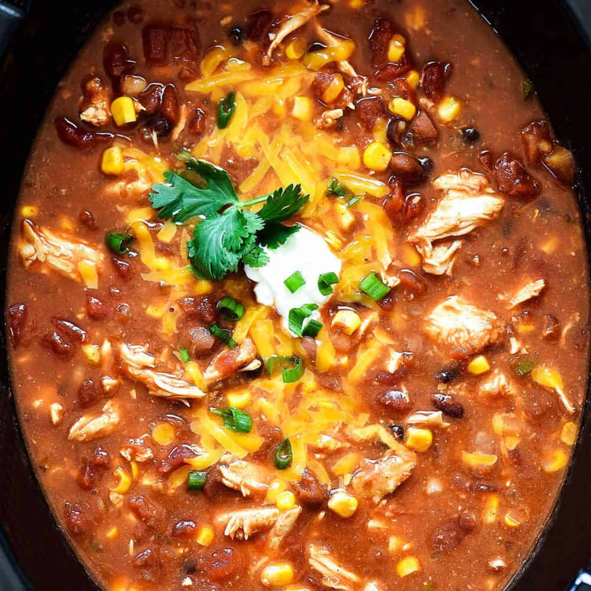 Taco soup with tender chicken, beans, corn, and tomatoes