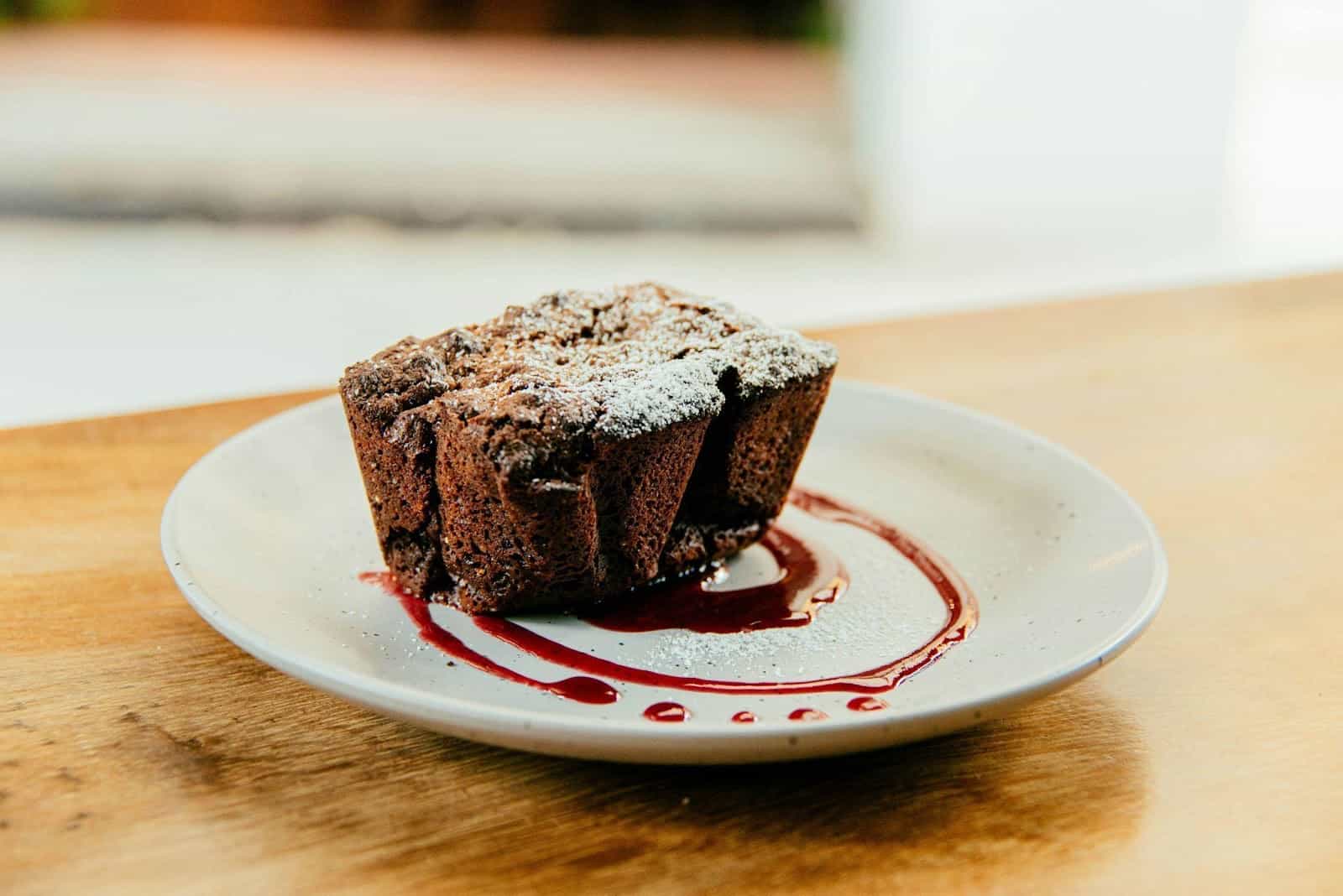 A slice of molten chocolate lava served with a sweet chocolate sauce