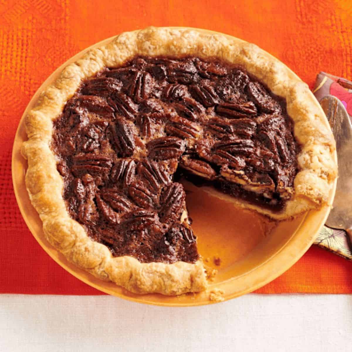 A beautifully arranged ancho chile-spiced pecan pie, showcasing a rich, glossy filling packed with pecans and a hint of spice.