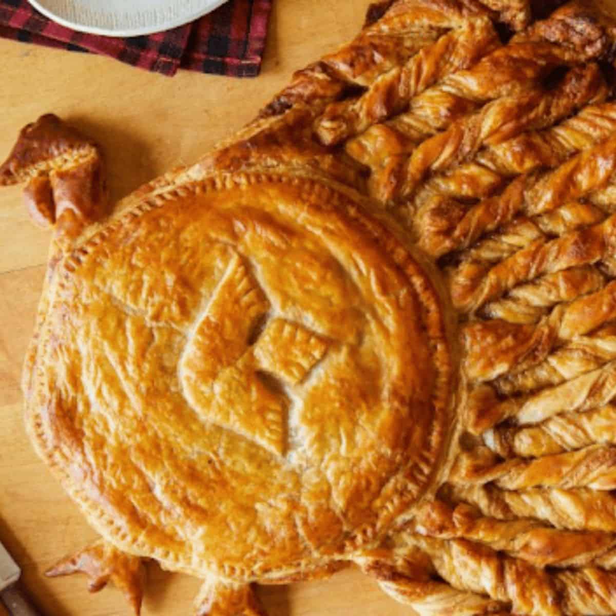 A festive apple pie puff pastry turkey, beautifully arranged with flaky pastry shaped like a turkey, filled with spiced apple filling.