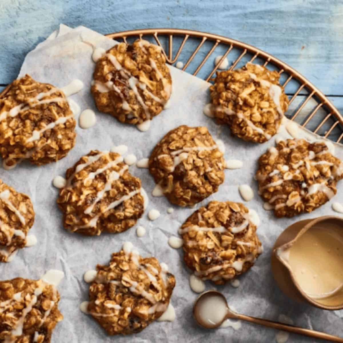 A display of chewy apple-cran-oatmeal cookies, featuring a golden-brown color, garnished with a sprinkle of oats on top, creating a warm and inviting treat perfect for fall.