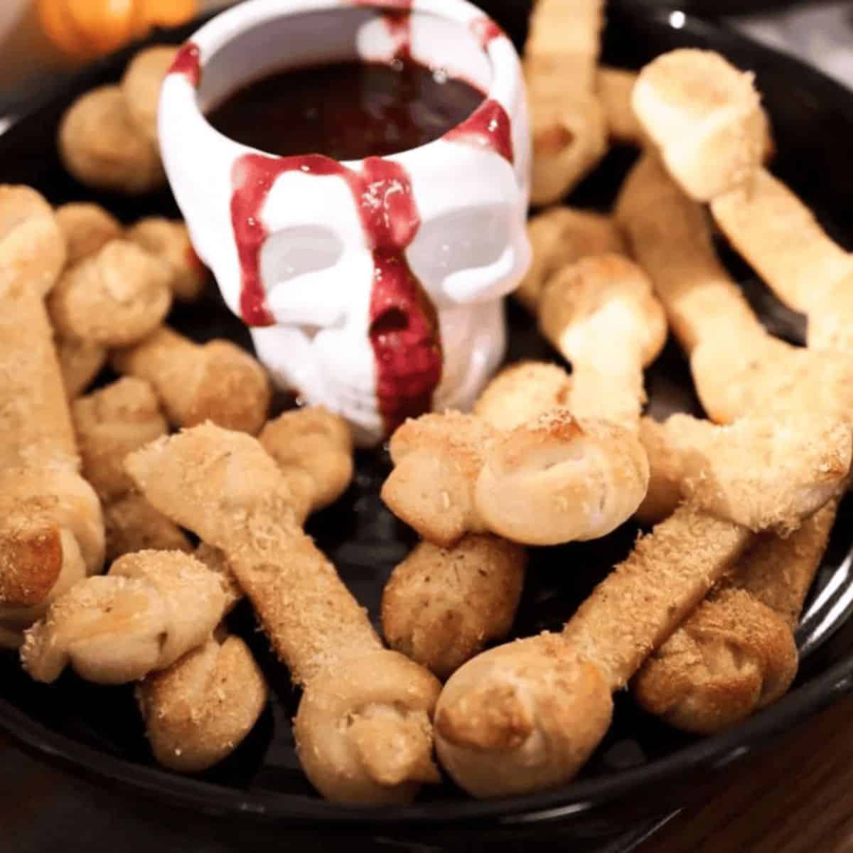 shaped like bones in a bowl with a skull mug and raspberry sauce that looks like blood.