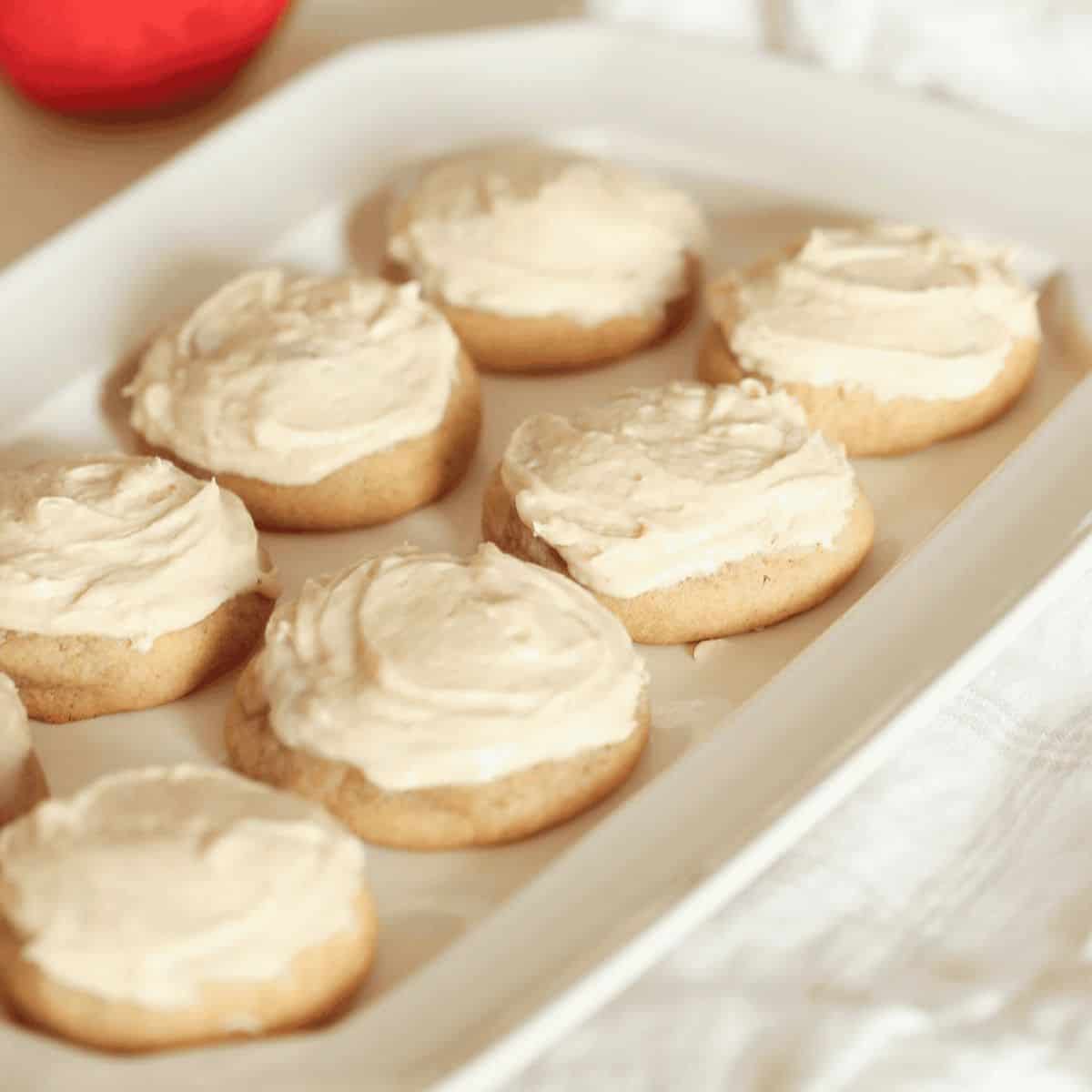 Delicious Frosted Apple Butter Sugar Cookies topped with cream frosting set in a tray.