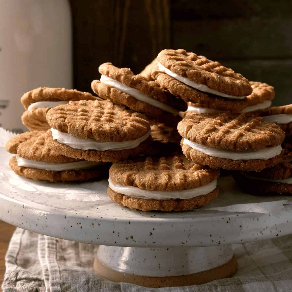 Delicious ginger creme sandwich cookies stacked on top of each other on a dessert tray.