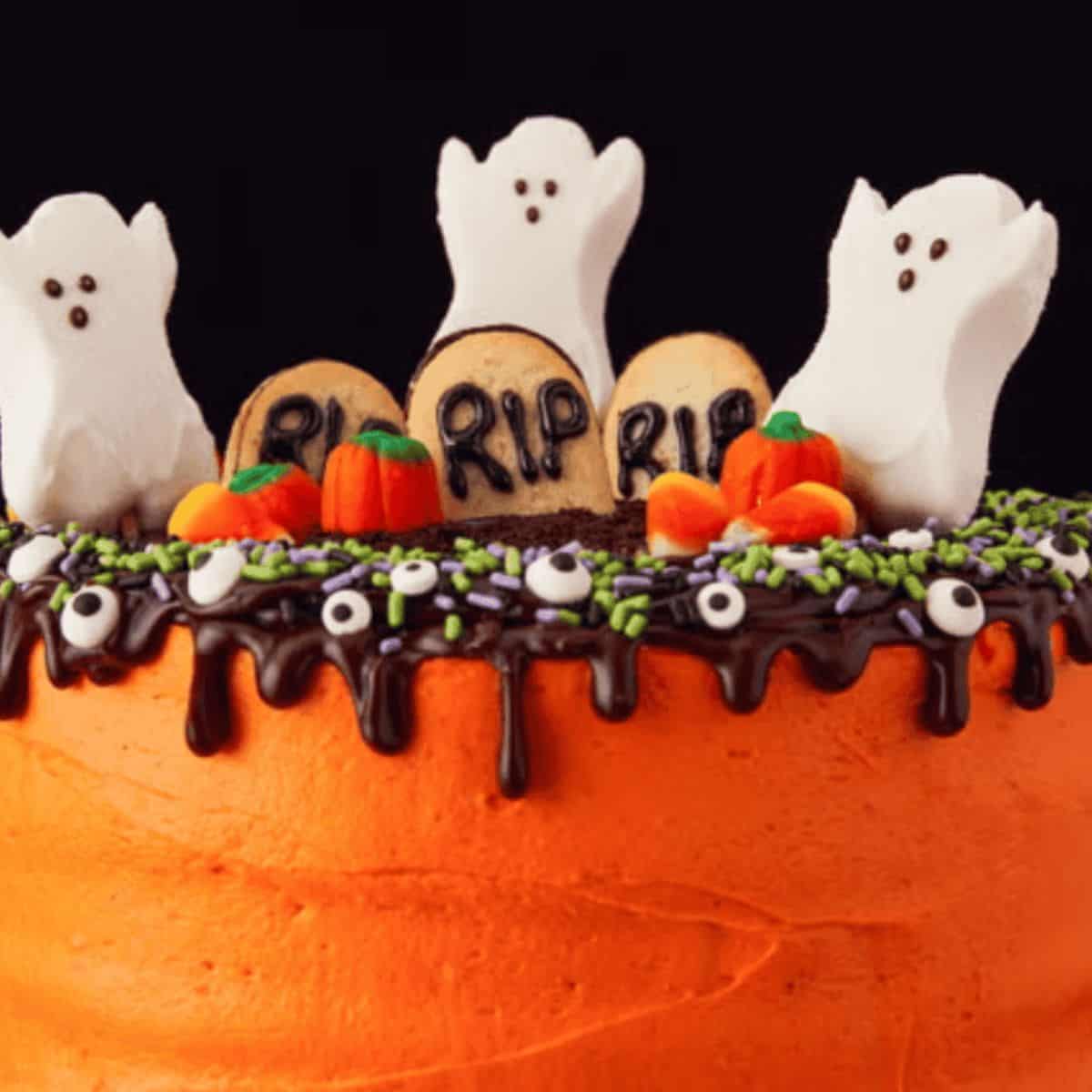 A delicious cake made with decorations that look like ghosts and mini graveyards on top.