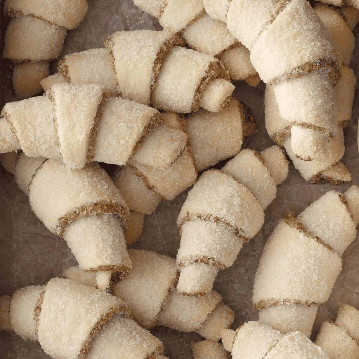 Horn walnut cookies, beautifully shaped into crescents and dusted with powdered sugar, showcasing their nutty walnut filling and inviting texture.