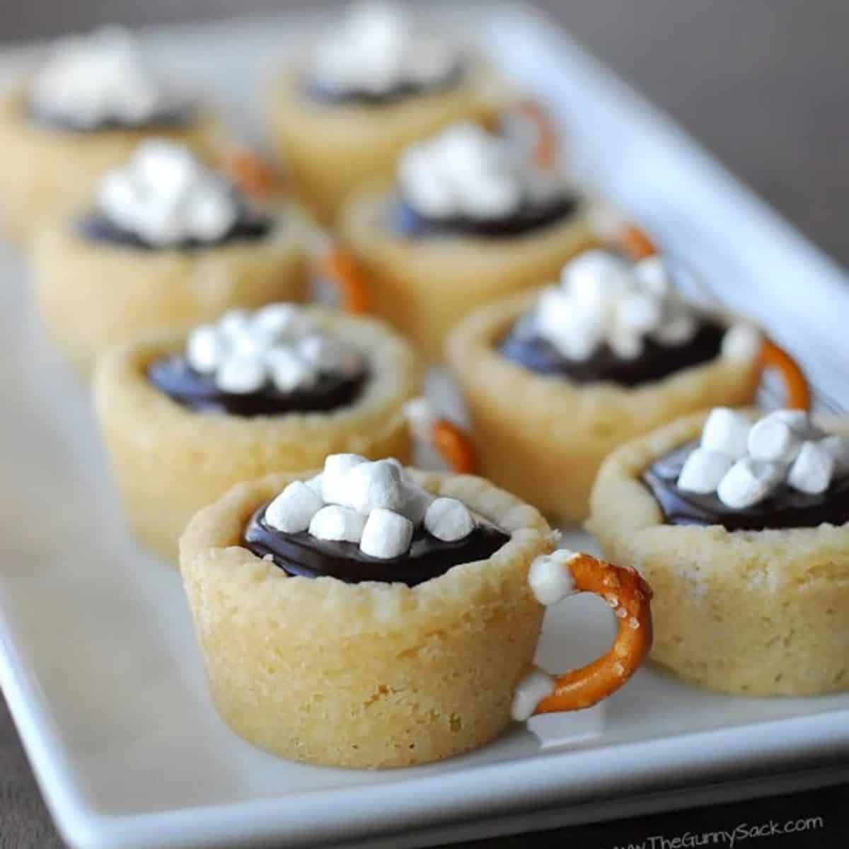 Multiple hot chocolate cookie cups arrranged in a white tray.