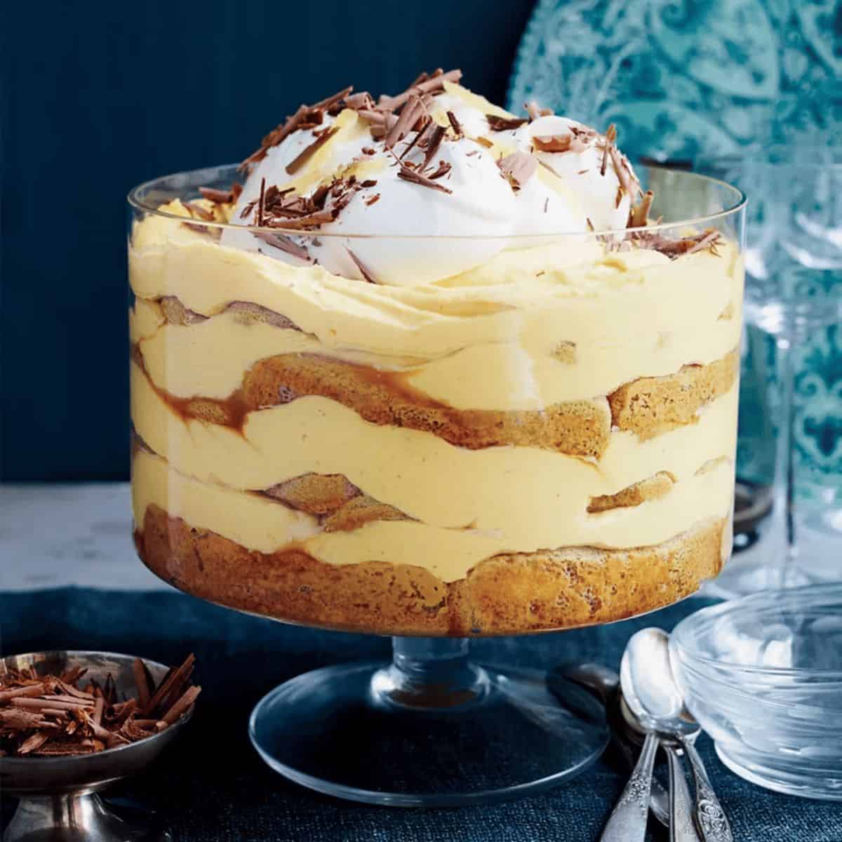 A delicious pumpkin tiramisu layered with creamy mascarpone and spiced pumpkin puree, dusted with chocolate flakes, served in a elegant dish, perfect for a festive dessert.