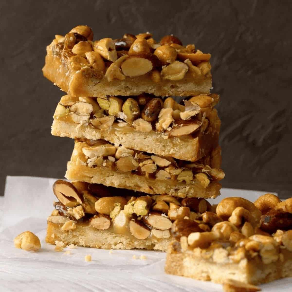 A pillar of rustic nut bars, showcasing a golden-brown crust packed with a mix of crunchy nuts and seed.