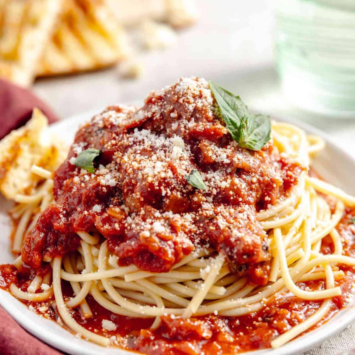 A delicious meal featuring spaghetti and meatballs, and a sprinkle of parmesan cheese on top. 