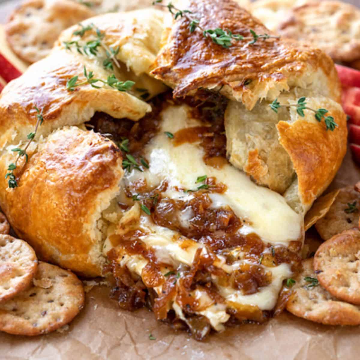 A yummy meal with baked brie and caramelized onions with crackers. 