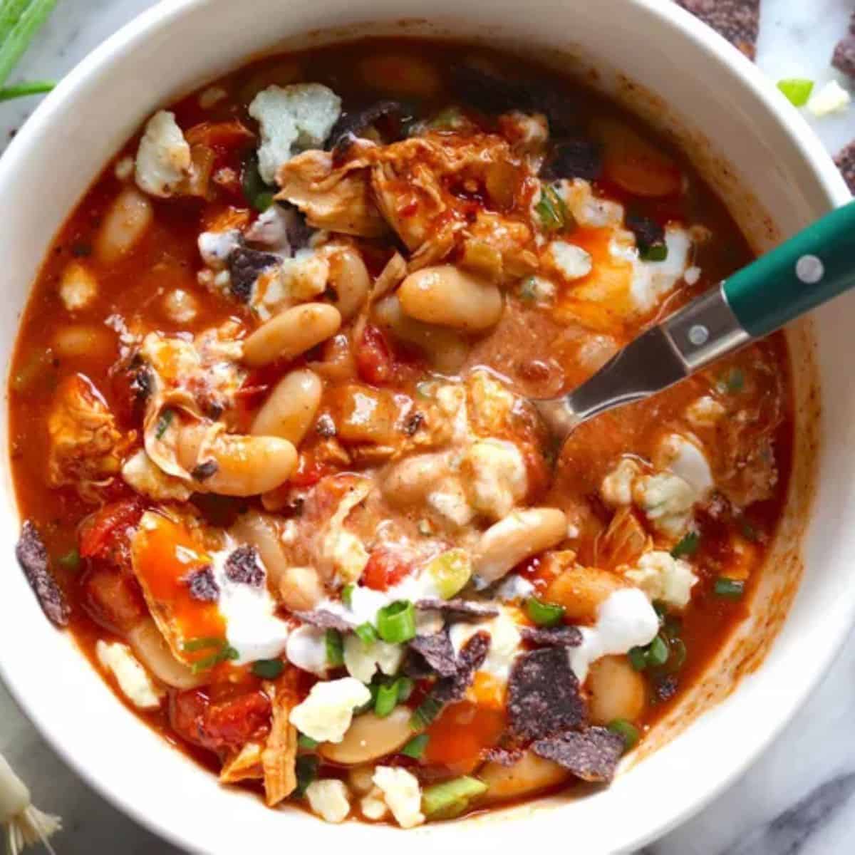 A zesty bowl of Buffalo Chicken Chili, made with shredded chicken, beans, tomatoes, and a tangy buffalo sauce, offering a spicy and comforting twist.
