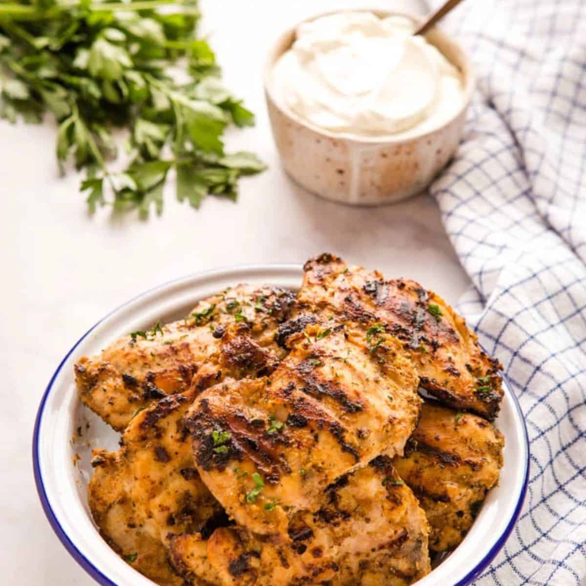 A flavorful meal with grilled chicken marinated with greek yogurt served in a ceramic dish. 