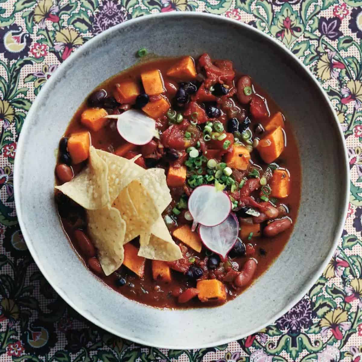 A hearty bowl of Slow-Cooker Vegetarian Chili with Sweet Potatoes, featuring tender sweet potatoes, beans, vegetables, and a flavorful blend of spices.
