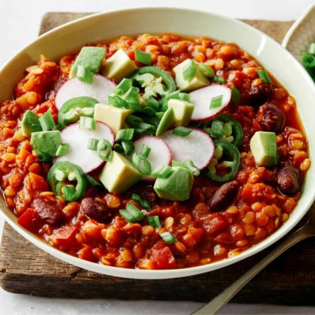 A hearty bowl of Vegan Lentil Chili, featuring protein-packed lentils, beans, vegetables, and spices in a rich, flavorful broth.
