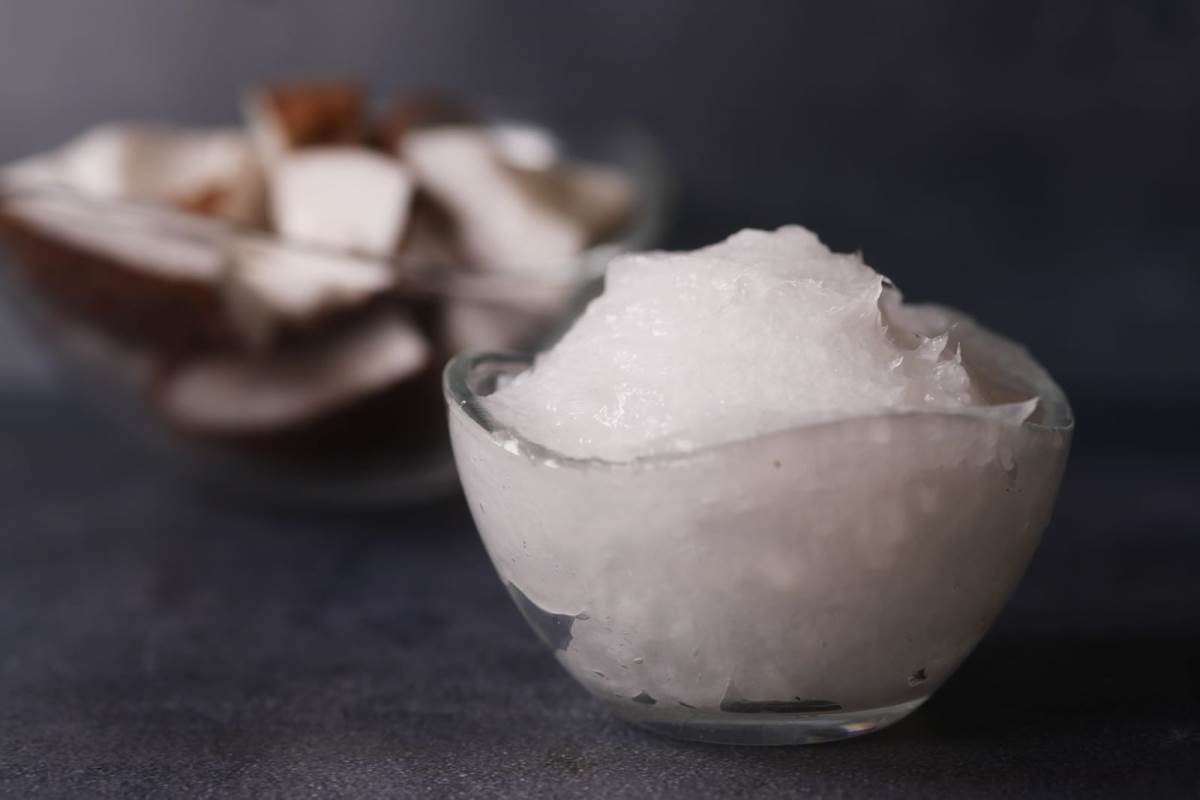 coconut oil and slice of coconut in background