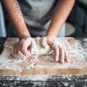baker hands kneading the dough with flour