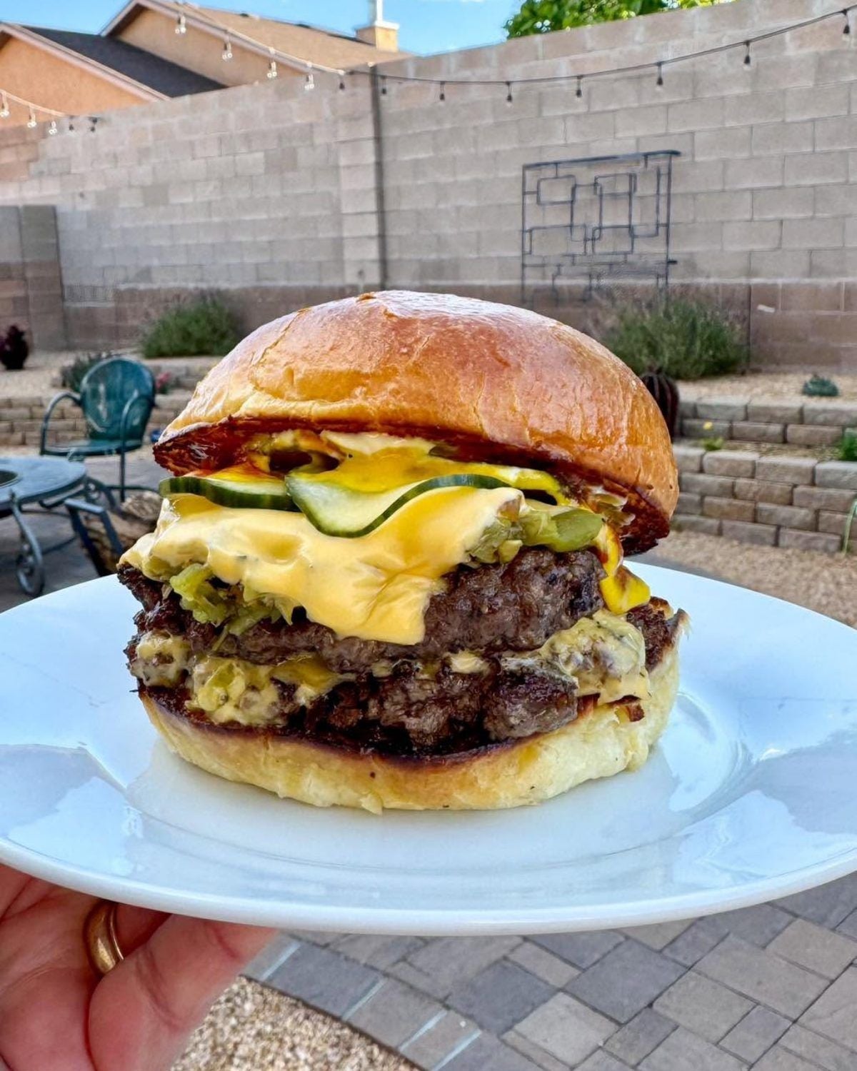 Double patty green chile smashed cheeseburger with melted cheese and pickles on a plate for an easy ground beef dinner recipe