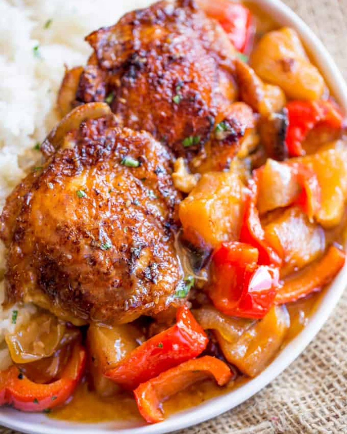 Hawaiian Pineapple Chicken in a slow cooker served over white rice with red bell peppers and pineapple chunks