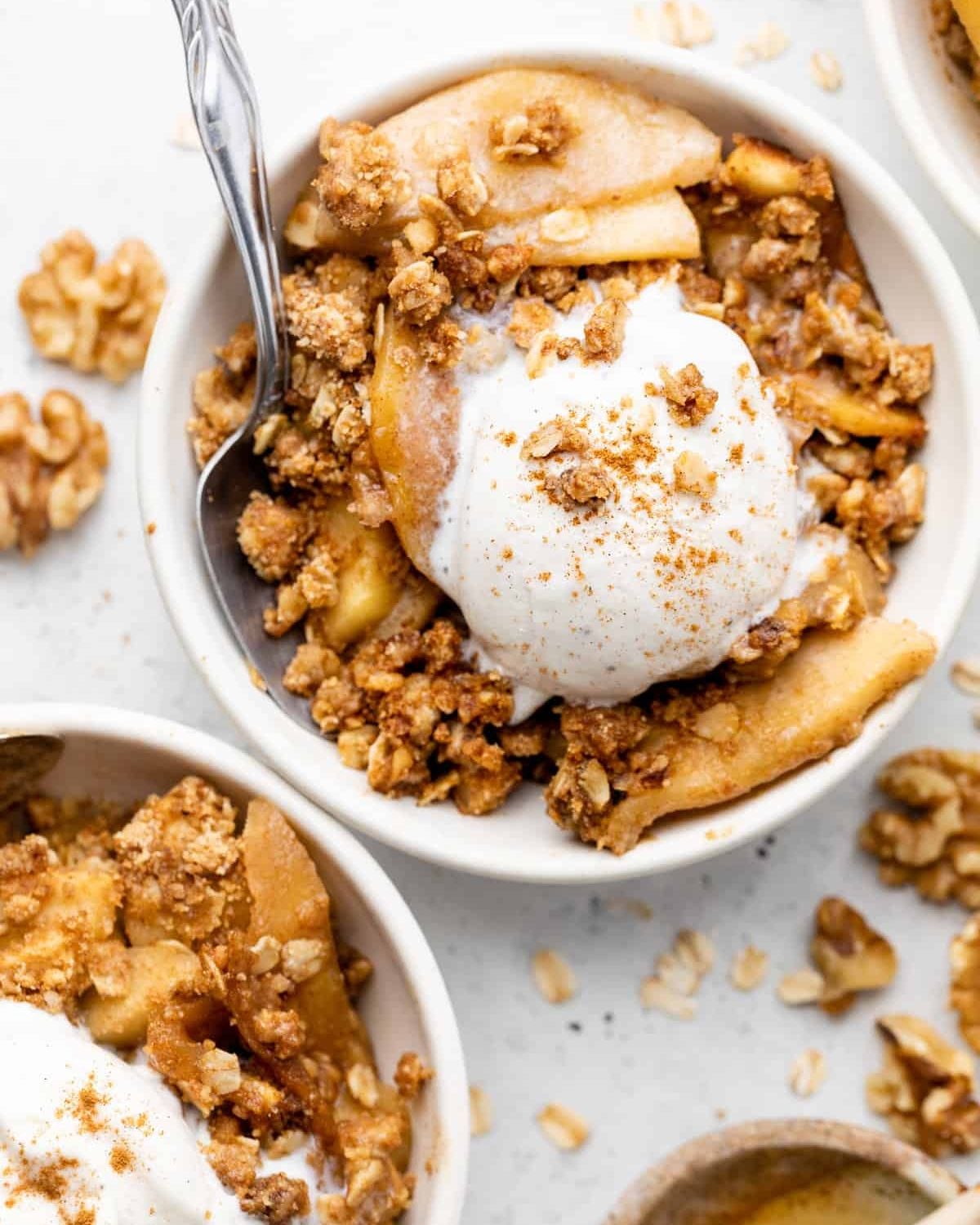 A bowl of apple crisp topped with ice cream and cinnamon, presented as healthy fall desserts